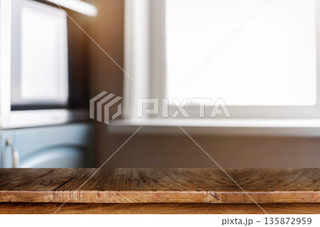 Wooden kitchen table with blurred home interior background Wooden kitchen table with blurred home interior background 135872959