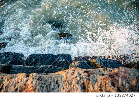 Beautiful sea at sunset near the rocky shore 135874027