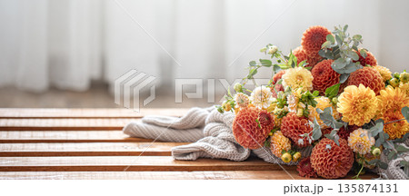 A bouquet of yellow and orange chrysanthemums on a blurred background. A bouquet of yellow and orange chrysanthemums on a blurred background. 135874131