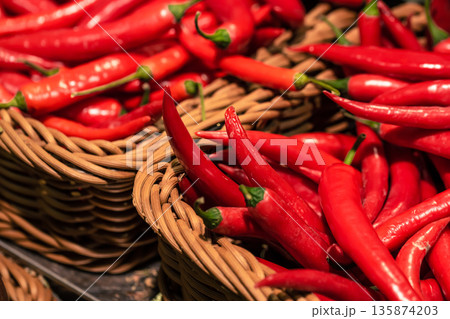 Chili peppers in a basket in a supermarket, close-up. Chili peppers in a basket in a supermarket, close-up. 135874203