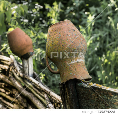 clay pot on an old fence in the village 135874228