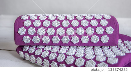 Purple massage acupuncture mat with pillow and white massage tips. 135874283