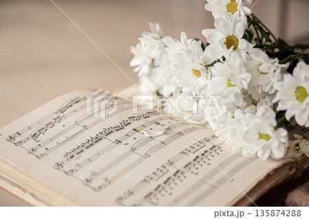 Close-up of musical notes and a bouquet of flowers. 135874288