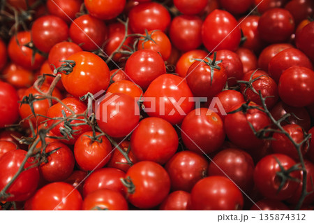 Close-up, small red tomatoes on the supermarket counter. Close-up, small red tomatoes on the supermarket counter. 135874312