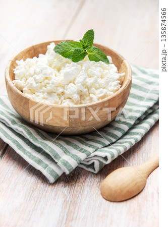 Cottage cheese in wooden bowl with mint leaf Cottage cheese in wooden bowl with mint leaf 135874566