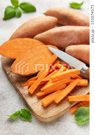 Sweet potato sticks with knife on wooden board 135874575