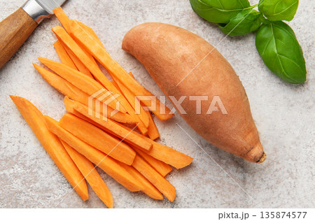 Preparing raw sweet potatoes for healthy fries with basil 135874577