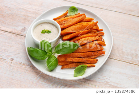 Sweet potato fries with dipping sauce and fresh basil 135874580