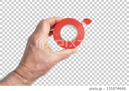 a roll of red electrical tape in the hand a roll of red electrical tape in the hand 135874698