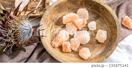 Spa composition with pieces of sea salt in a wooden plate. 135875141