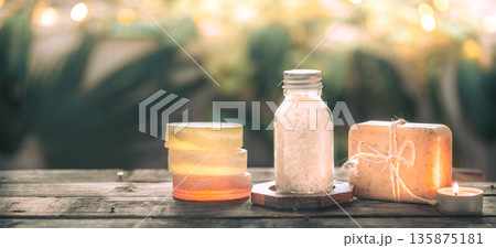 Spa handmade soap with sea salt, composition on tropical leaves with a candle, wooden background 135875181