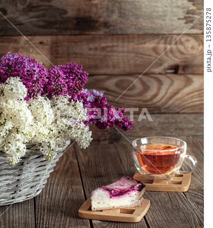 Spring composition lilac flowers in a basket on a wooden background. 135875278
