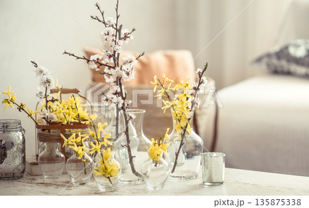 Still life with vases with spring flowers in the living room 135875338
