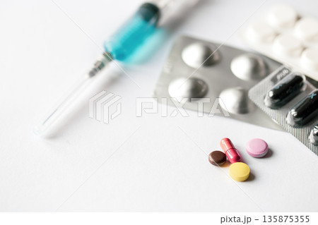 Syringe and pills on a white background isolated, close-up. 135875355