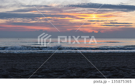 Texture sea waves at sunset with pink clouds. 135875365