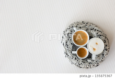 Three cups of coffee on a white texture background, flat lay. 135875367