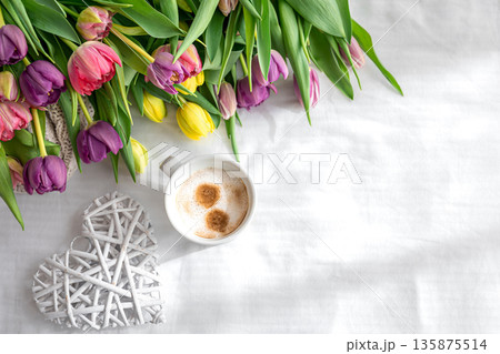 Cozy composition with flowers and coffee on a white background, top view. Cozy composition with flowers and coffee on a white background, top view. 135875514