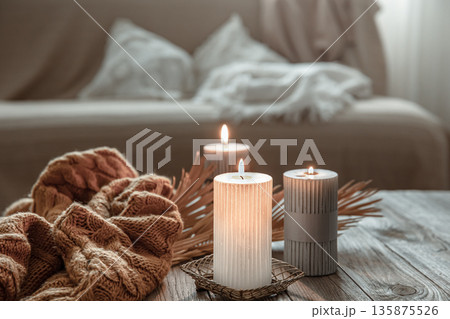 Flaming candles on the table in the interior of the room. Flaming candles on the table in the interior of the room. 135875526