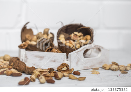 different nuts closeup on white wooden background 135875582