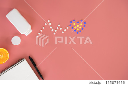 Flat lay, heart cardiogram, pills on pink background, conceptual minimalism. 135875656