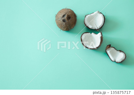 Fresh split coconut on a blue background. 135875717