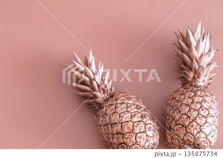Gold colored pineapple on a colored background. Tropical flat lay. Food concept. 135875734