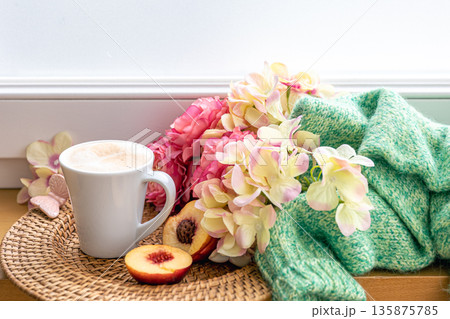 Home composition with a cup of coffee, flowers and a knitted element. Home composition with a cup of coffee, flowers and a knitted element. 135875785