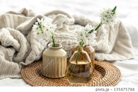 Home composition with flowers in vases and a knitted element. Home composition with flowers in vases and a knitted element. 135875788