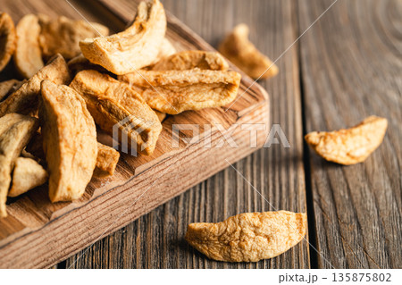 Homemade dried organic apple sliced on wood background. 135875802