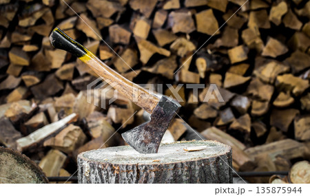 the old axe stuck in a stump 135875944