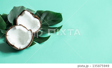 Natural Monstera leaf with coconut on a blue background. Natural Monstera leaf with coconut on a blue background. 135875949