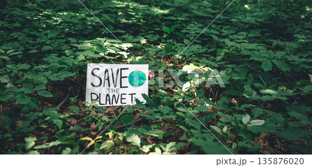 Poster with the inscription save the planet in the forest among the plants. 135876020