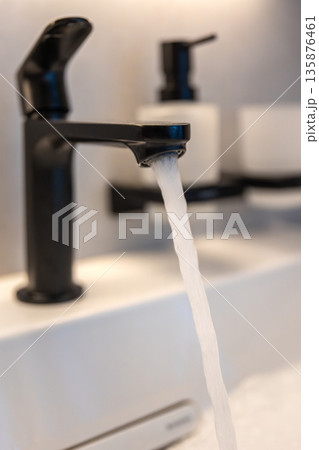 Black faucet stream. White basin. Modern hygiene 135876461