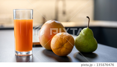 Carrot juice glass with board and knife in prep mode. Cozy smoothie vibe. Carrot juice glass with board and knife in prep mode. Cozy smoothie vibe. 135876476