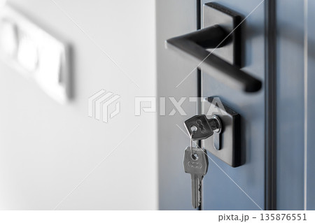 Keys in lock. Blue door panel. Clean space. Keys in lock. Blue door panel. Clean space. 135876551