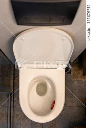 Toilet top view. Minimal restroom. Stone tiles Toilet top view. Minimal restroom. Stone tiles 135876712