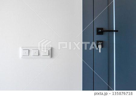 Triple switches. Blue door. Key in lock. Triple switches. Blue door. Key in lock. 135876718