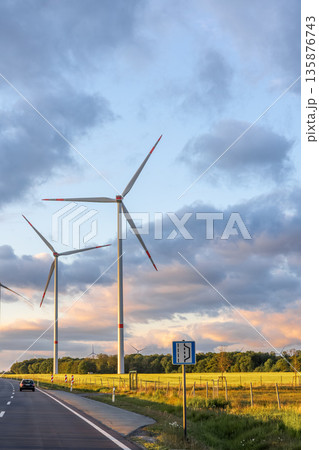 Wind turbines in field. Road through green fields. Alternative energy and nature 135876743