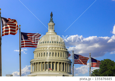 American flags fly next to Capitol building in Washington D.C. on sunny day with blue skies, clouds above. American flags fly next to Capitol building in Washington D.C. on sunny day with blue skies, clouds above. 135876885