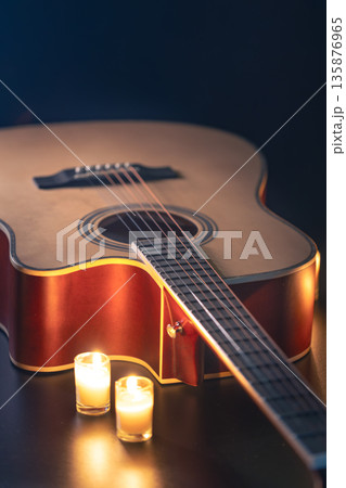 Acoustic guitar on a black background with candles. Acoustic guitar on a black background with candles. 135876965