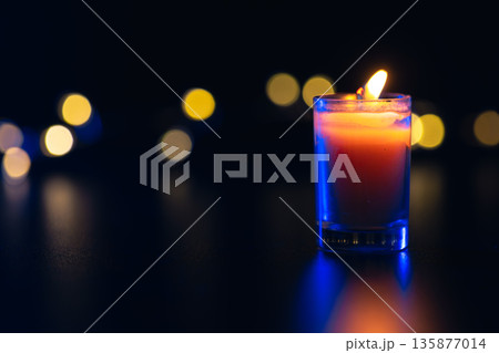 Burning candle on black background with bokeh. Memorial Day. 135877014
