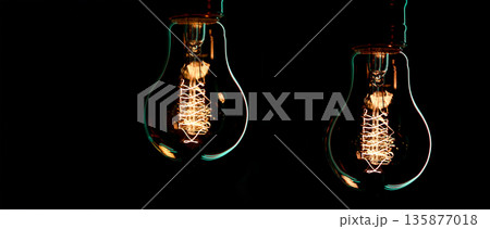 A burning lamps hangs in the dark on a blurred background. Space for text. 135877018