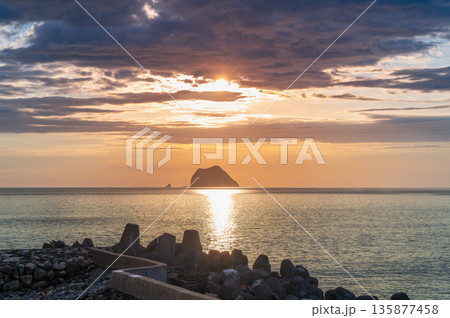 Silhouette of a Ship Passing Keelung Islet at Sunrise in Taiwan. 135877458