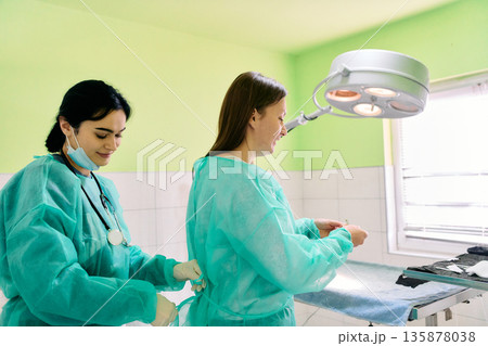 Medical Team Assists Patient In Bright Operating Room During Surgery 135878038