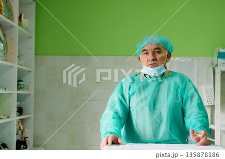 Medical Professional In Surgical Gown And Cap In Clean Clinic Setting During Procedure 135878186