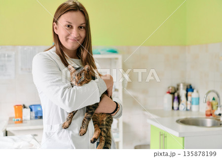 Young Woman Veterinarian Holds Cat in Bright Modern Pet Clinic for Care and Comfort Young Woman Veterinarian Holds Cat in Bright Modern Pet Clinic for Care and Comfort 135878199
