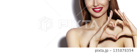 Smiling beautiful woman forming heart shape with hands. Valentine Day concept, happy girl, bright makeup for date, red lipstick. Beauty mockup for cosmetic branding, romantic mood, feminine style Smiling beautiful woman forming heart shape with hands. Valentine Day concept, happy girl, bright makeup for date, red lipstick. Beauty mockup for cosmetic branding, romantic mood, feminine style 135878354