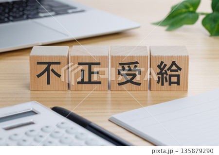 テーブルの上に不正受給と書かれたブロック テーブルの上に不正受給と書かれたブロック 135879290