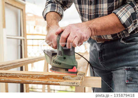 Carpenter at work, restoring an old wooden window. Carpentry. Carpenter at work, restoring an old wooden window. Carpentry. 135879418