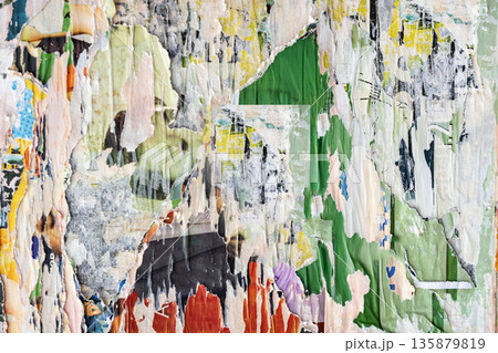 Abstract close-up of Torn urban poster wall collage of layered paper, bright rough grunge textures. Distressed paper surface, peeling paint, graphic fragments. Trendy background, modern art concepts 135879819